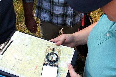 Employee using map & compass for orientation