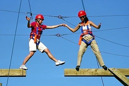 Two employees team building in the high ropes course