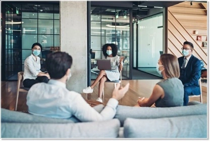 Employee team with masks at a meeting during the coronavirus pandemic