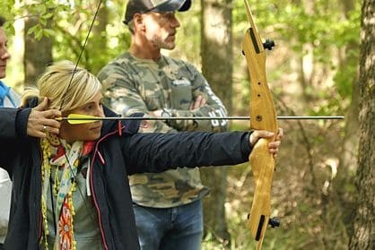 Employee shooting a bow Employee doing archery during a team event