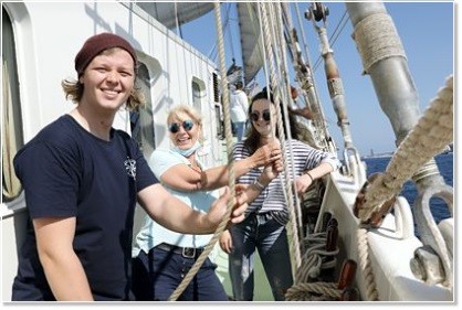 Employees setting sail on a traditional sailing ship